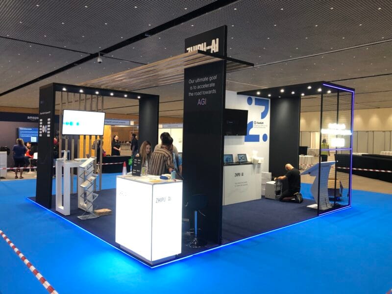 Innowacyjne stoisko targowe Zhipu-AI na targach KDD w Barcelonie, prezentujące rozwiązania AI, wykonane przez europejską firmę budującą stoiska