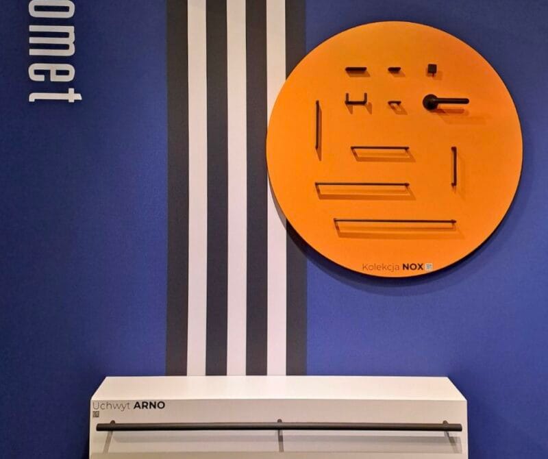 Stoisko na targach Architect@Work z produktami zamocowanymi na ścianach.