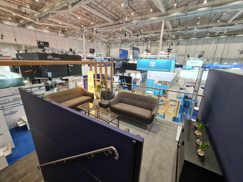Wnętrze stoiska BSS – SMM 2026 Wnętrze piętra stoiska BSS z ekranem i przestrzenią spotkań na SMM Hamburg 2026
